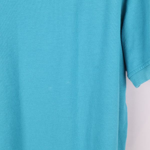 Detaljbild på tyg och ärm hos turkos t-shirt