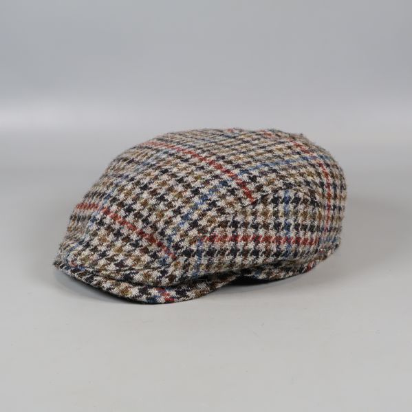 Rutigt keps i fiskbensmönster på ljus bakgrund