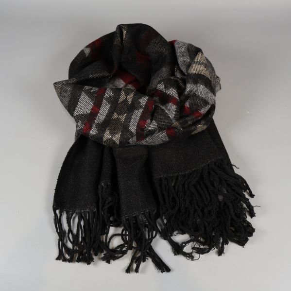 Närbild på hopvikt halsduk med mönster och fransar