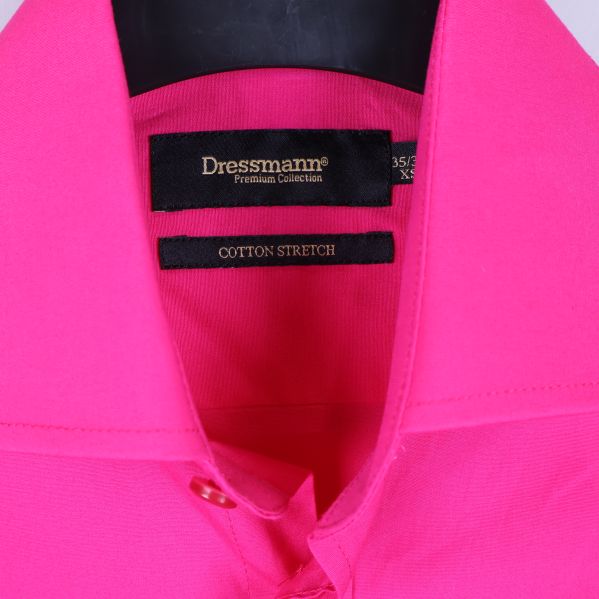 Närbild på krage och Dressmann-etikett på kritrosa skjorta