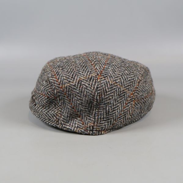 Baksida på fiskbensmönstrad tweedkeps med synliga detaljer