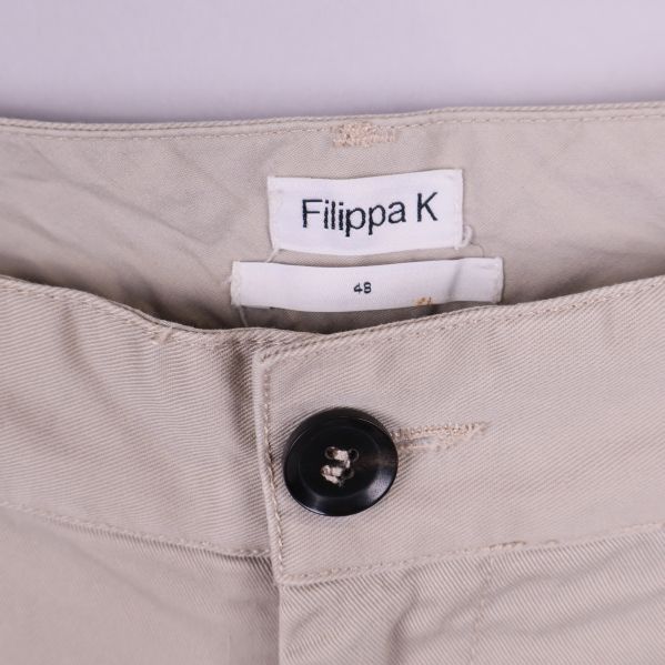 Detaljbild på Filippa K-logotyp och knapp i midjan