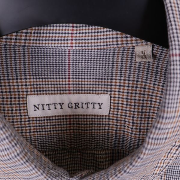 Närbild på etikett med text Nitty Gritty insydd i skjortan