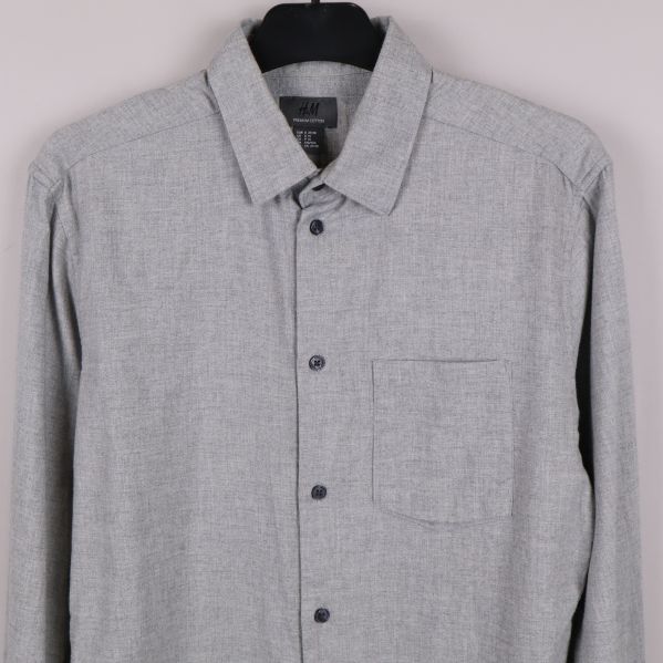 Framdel av grå skjorta med krage och knappslå