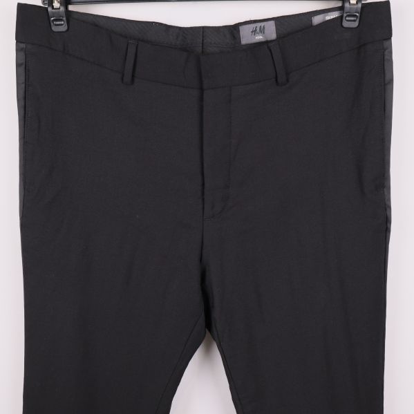 Detalj av midja och gylf på svarta byxor