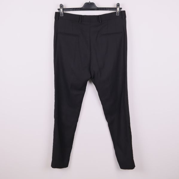 Baksida på svarta kostymbyxor med fickor