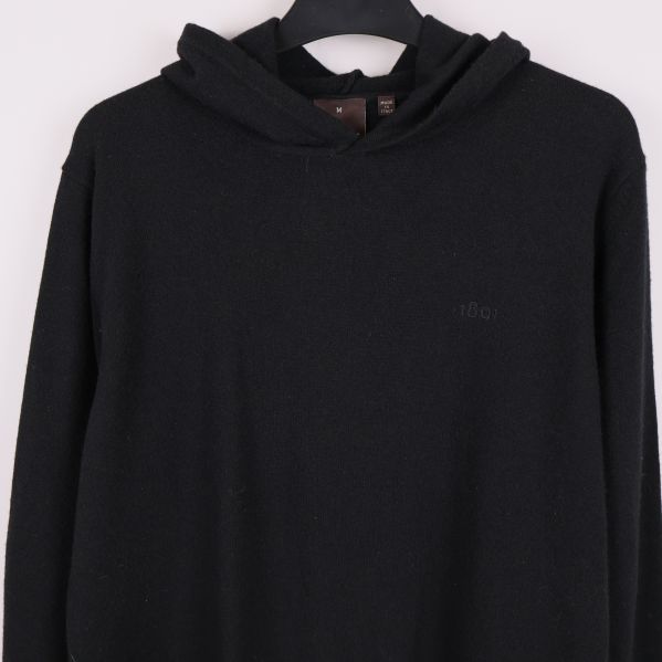 Detalj av bröstlogo och huva på svart hoodie