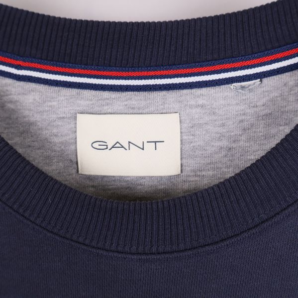 Detalj av GANT-logotyp i nacken på tröjan