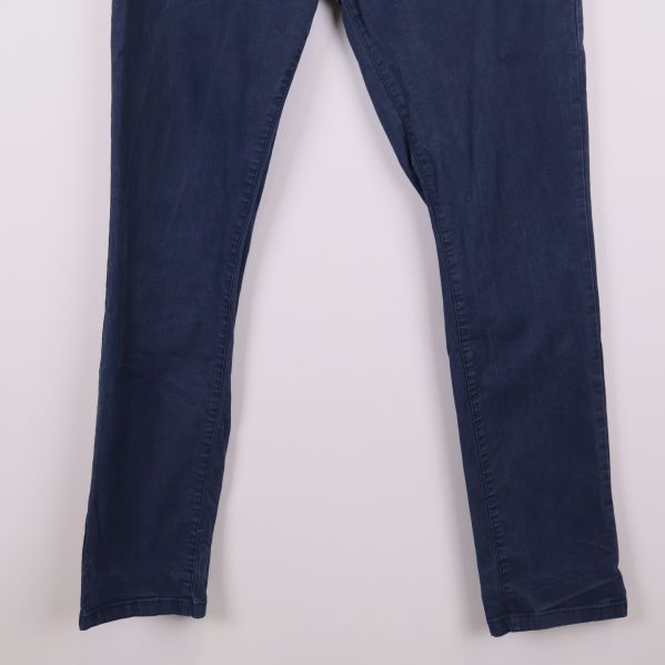 Närbild på ben och fotvidd hos mörkblå chinos