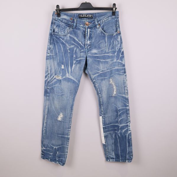 Framsidan av ljusblå jeans med slitningar och unikt mönster