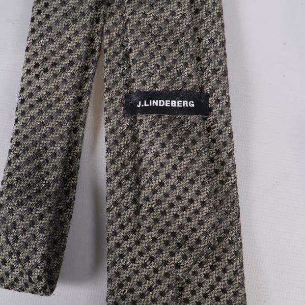 Närbild på J.Lindeberg etikett på baksidan av slipsen