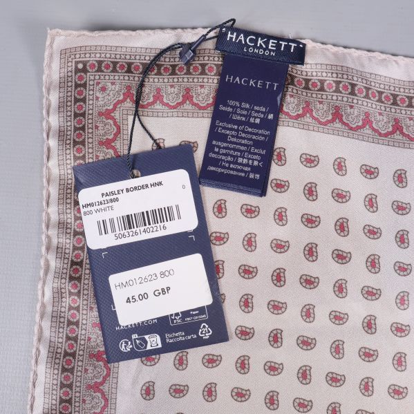 Två etiketter från Hackett London bredvid tygkanter och paisleymönster