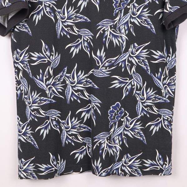 Närbild på pikétröjans blommönster och material