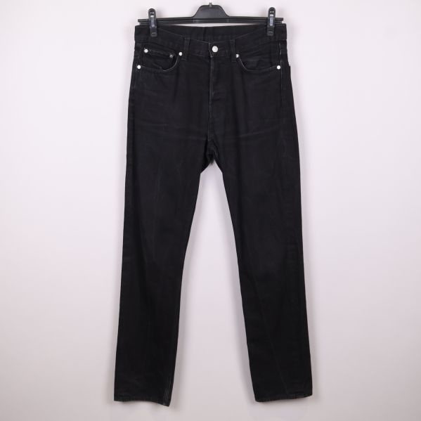 Svarta raka jeans hängande på galge framifrån