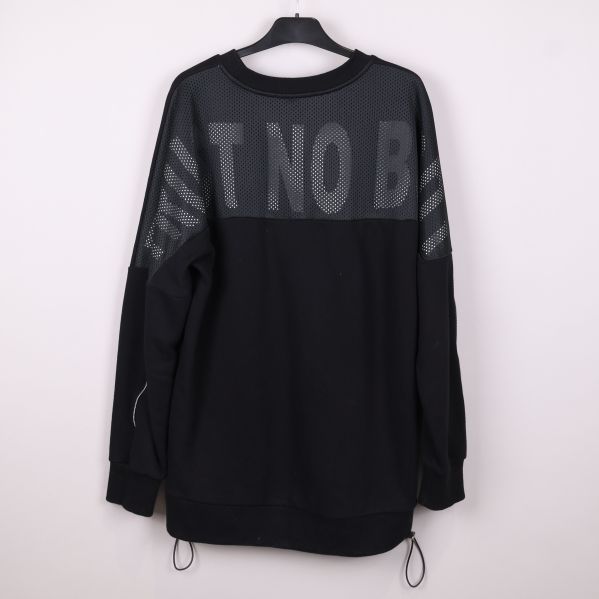 Baksida av svart sweatshirt med stora meshinslag och textmönster