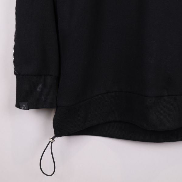 Nederkant av svart sweatshirt med dragsko och mudd med fläckt