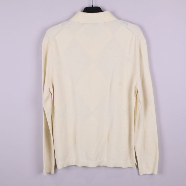 Baksida av ljusbeige stickad tröja med rutmönster