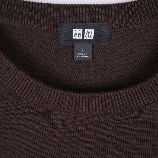 Närbild på Uniqlo-logo och halsringning på brun tröja