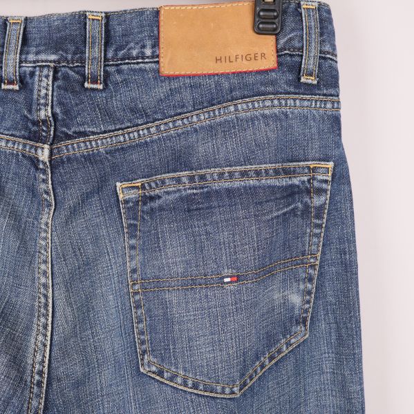 Bakfickor av blå jeans med logotyp