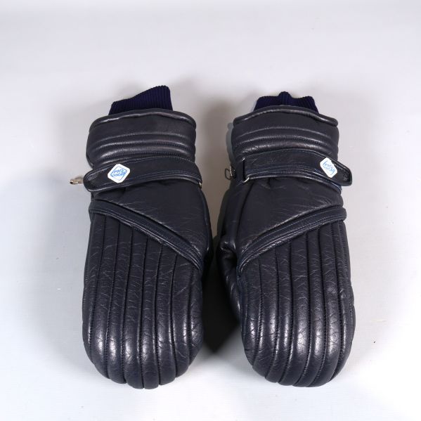 Ett par mörkblå vadderade vantar framifrån