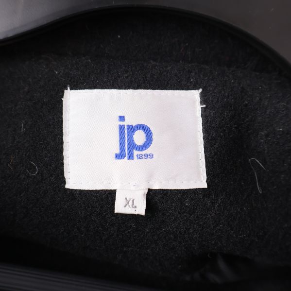 Närbild på etikett med blå jp logotyp och XL storlek