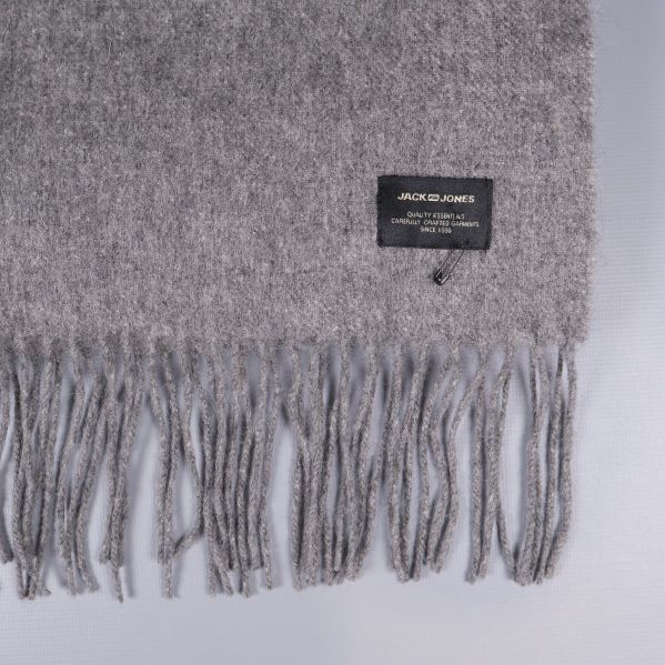 Närbild på halsdukens franskant och svart etikett