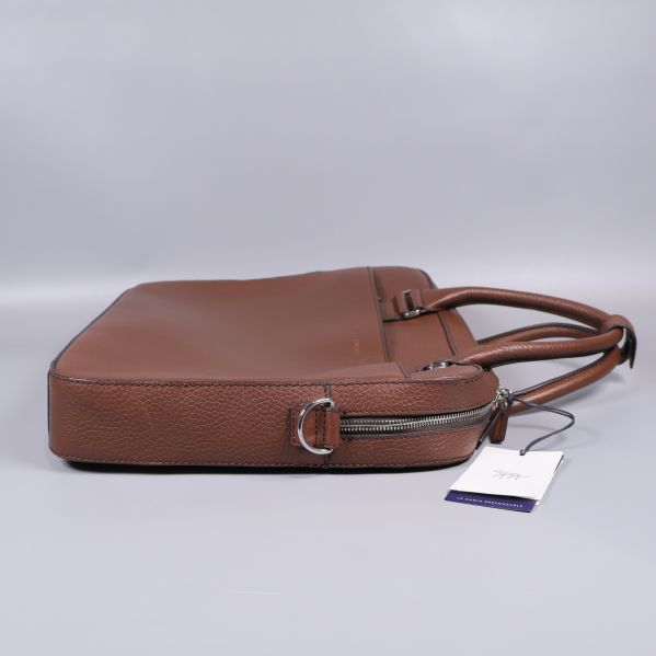 Vänster sida av brun väska med metallring