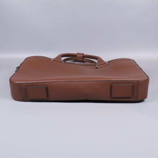 Undersidan av brun datorväska med skyddande fötter