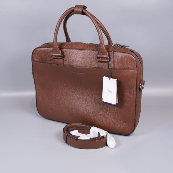 Brun datorväska med axelrem i förgrunden