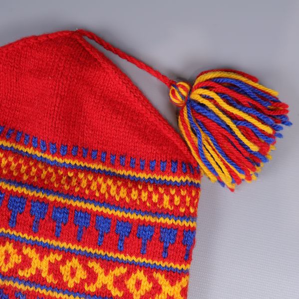 Närbild på tofs i rött, blått och gult