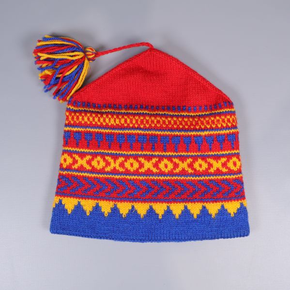 Stickad mössa med tofs sedd framifrån och bakifrån