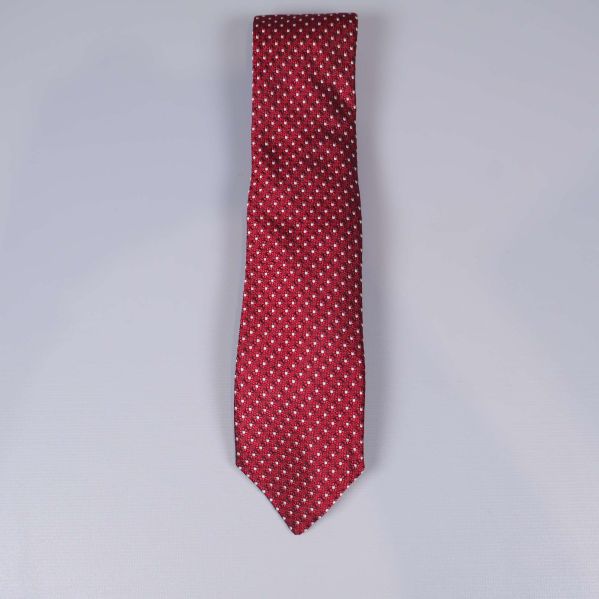 Vinröd slips med vitt mönster utlagd på bordet