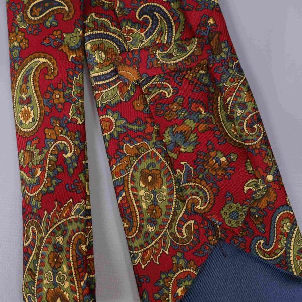 Närbild av paisleymönstret på röd slips