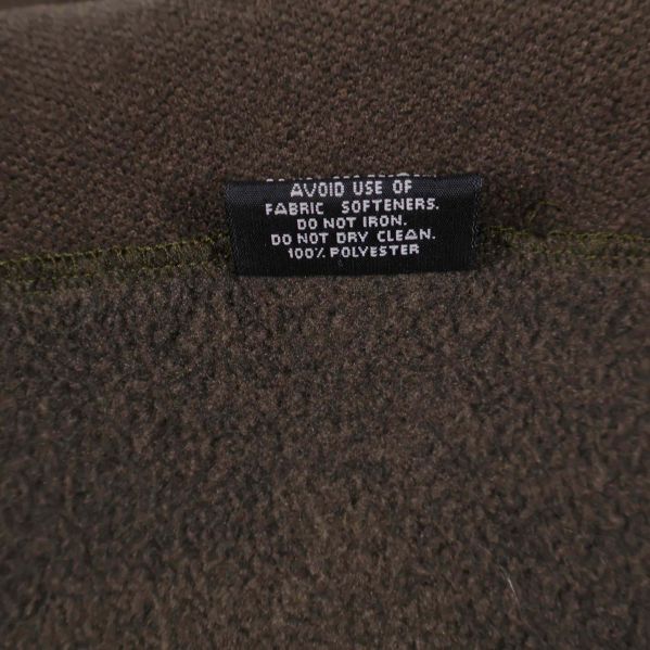 Materialetikett visar 100% polyester på fleecescarf