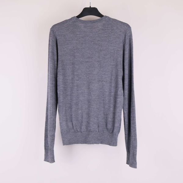 Baksidan av grå stickad tröja med långa ärmar