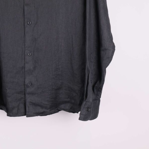 Nederkant av svart skjorta med knappslå och manschett