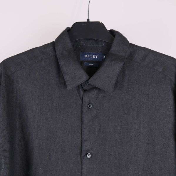 Övre delen av svart skjorta med krage och knappar