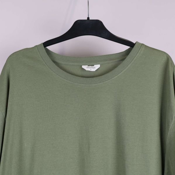 Närbild på halsringning av grön t-shirt