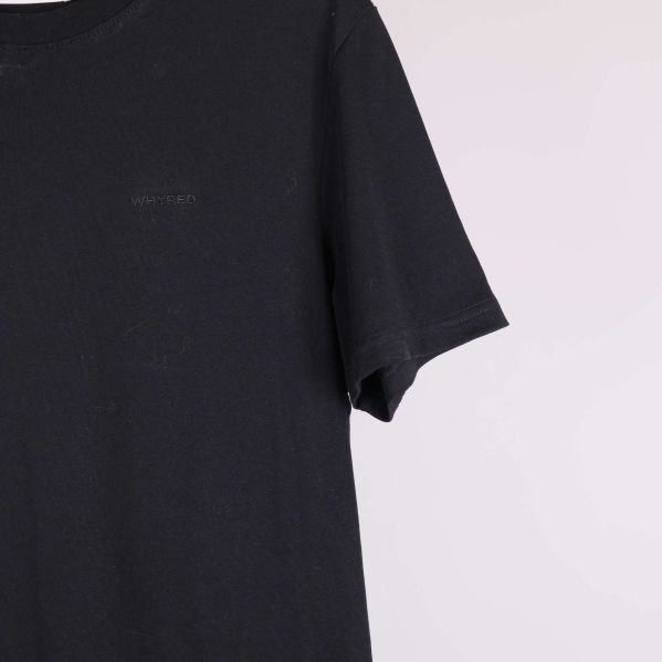 Närbild på högra ärmen och sidan av svart t-shirt