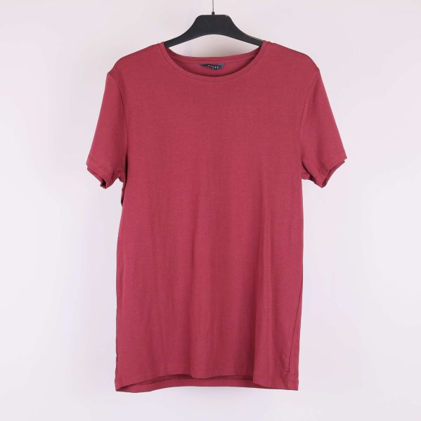 Röd t-shirt på galge i helbild framifrån