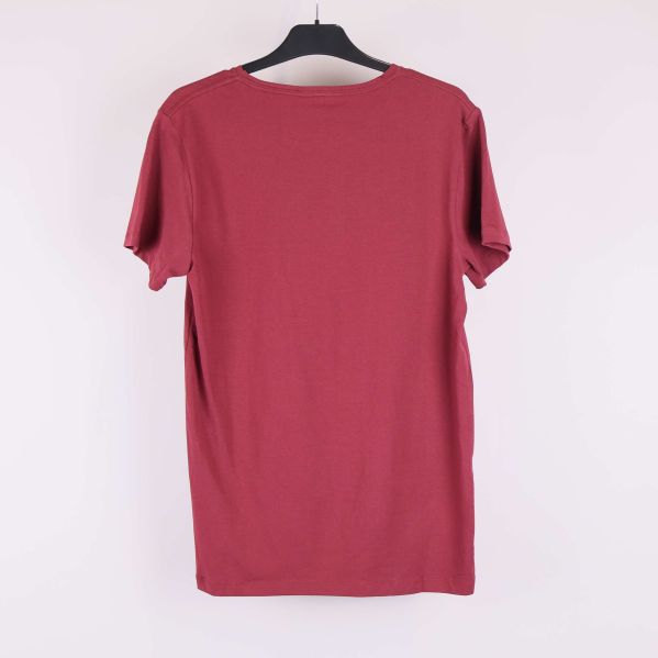 Röd t-shirt på galge i helbild bakifrån