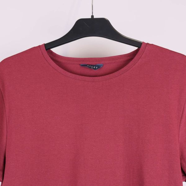 Närbild på halsringning och axel söm på röd t-shirt