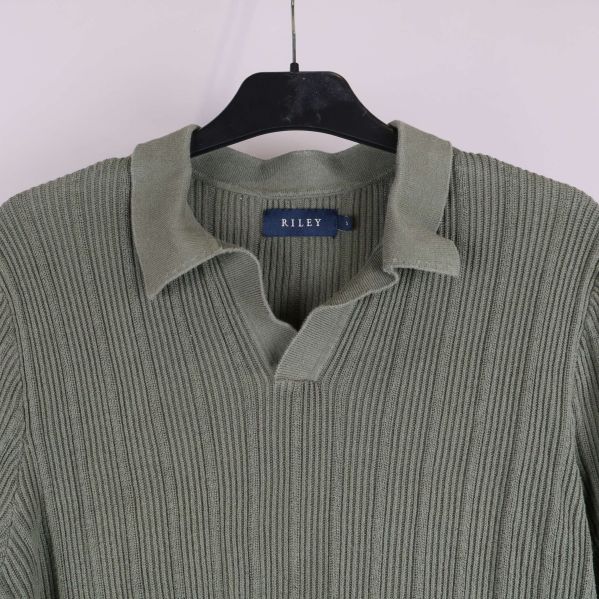 Närbild på krage och halsringning i stickad tröja