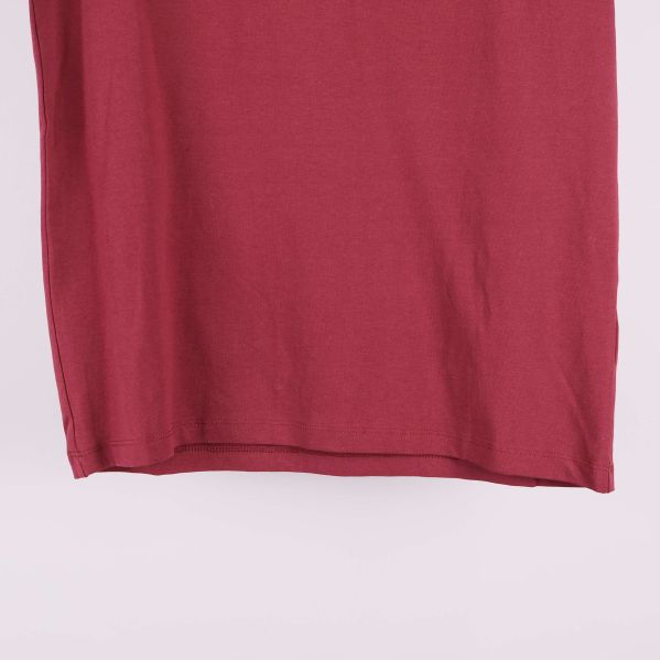 Nedre del av röd t-shirt i närbild