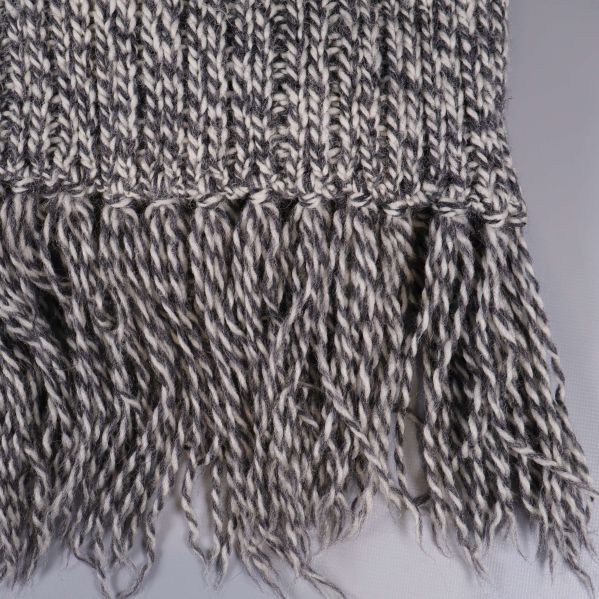 Närbild på tvinnade fransar på halsduk