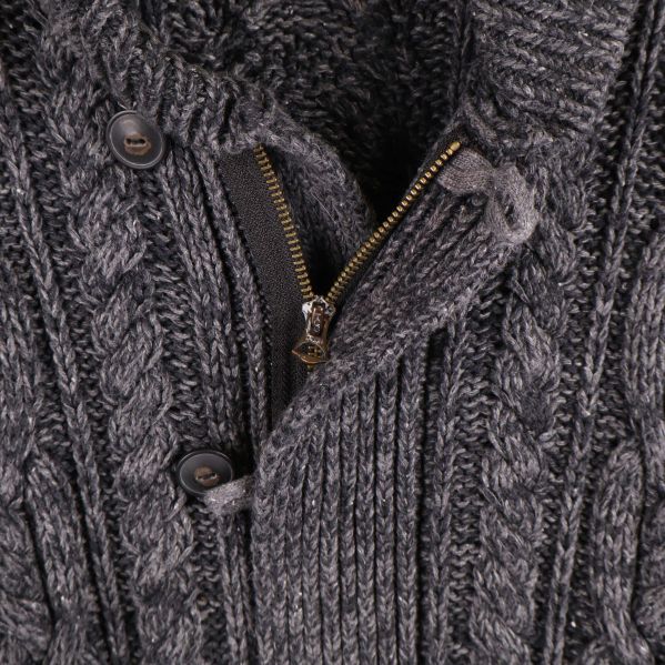 Närbild på dragkedja och knappar på koftan