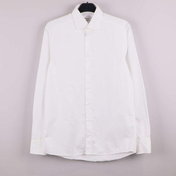 Vit skjorta med lång ärm upphängd mot ljus bakgrund