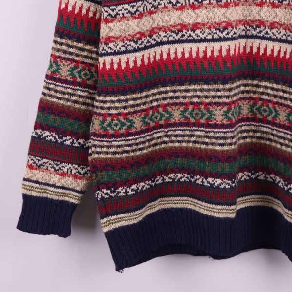 Nederdel av tröja med blå muddar och vävt mönster