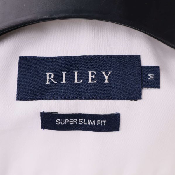 Närbild av Riley-märke och passformsinformation i skjortkragen