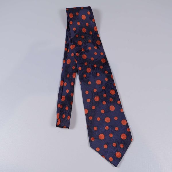 Prickig slips i mörkblått och orange utlagd på bord